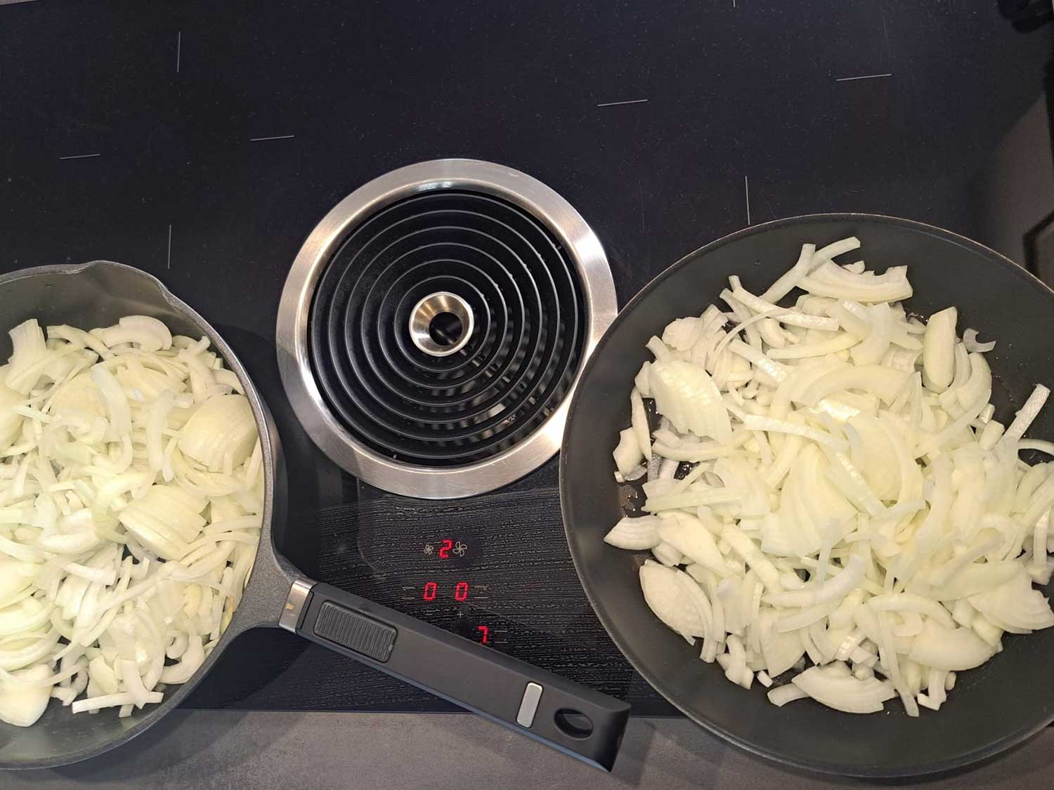Zwiebel werden auf einem Herd in einer Pfanne gedünstet