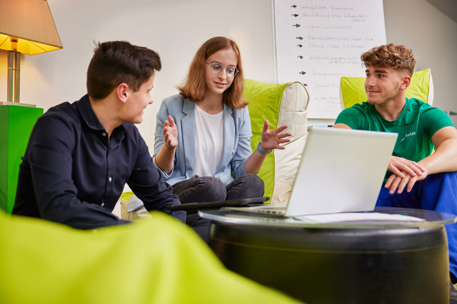 Drei Azubis besprechen etwas am Laptop