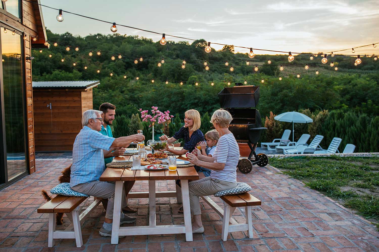 Glückliche fröhliche Familie beim gemeinsamen Essen draußen auf der Terrasse