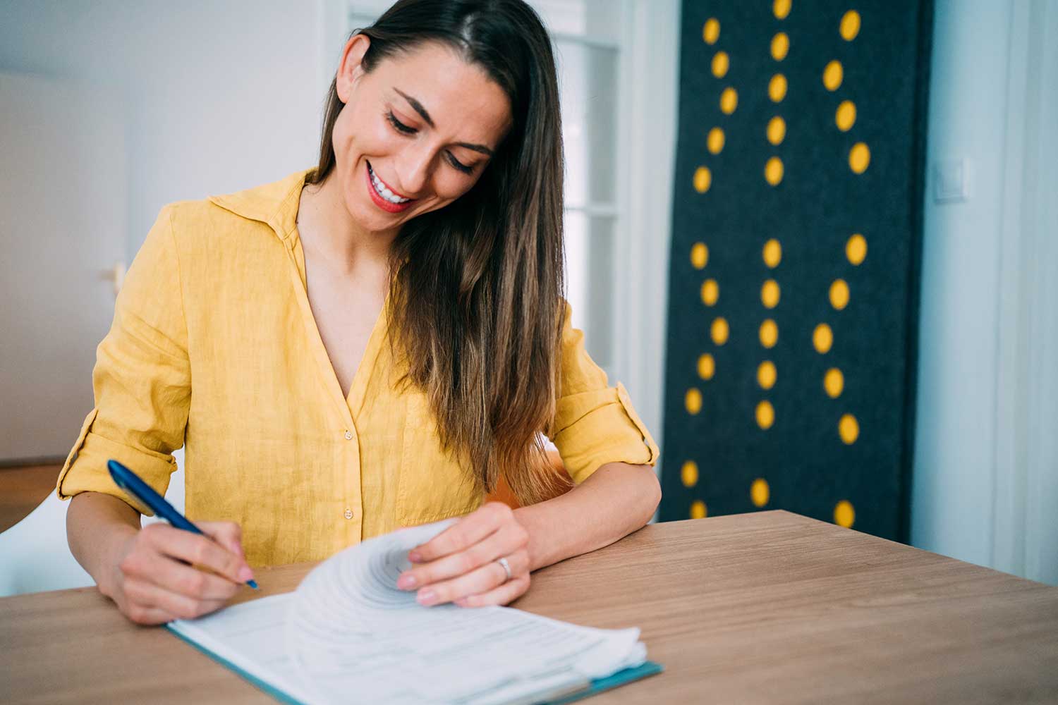 Frau, die am Schreibtisch Dokumente schreibt
