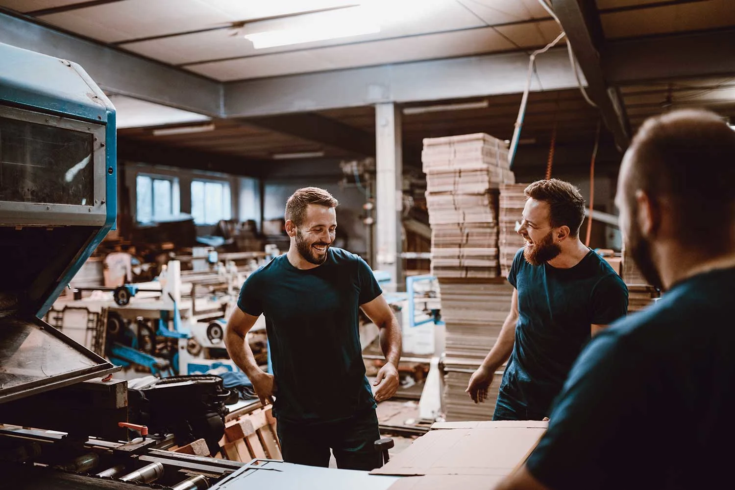 Drei junge Männer arbeiten in einer Druckerei