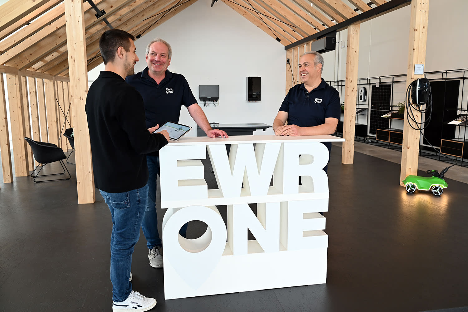 EWR One Kollegen beraten an einem EWR One Logo Tisch