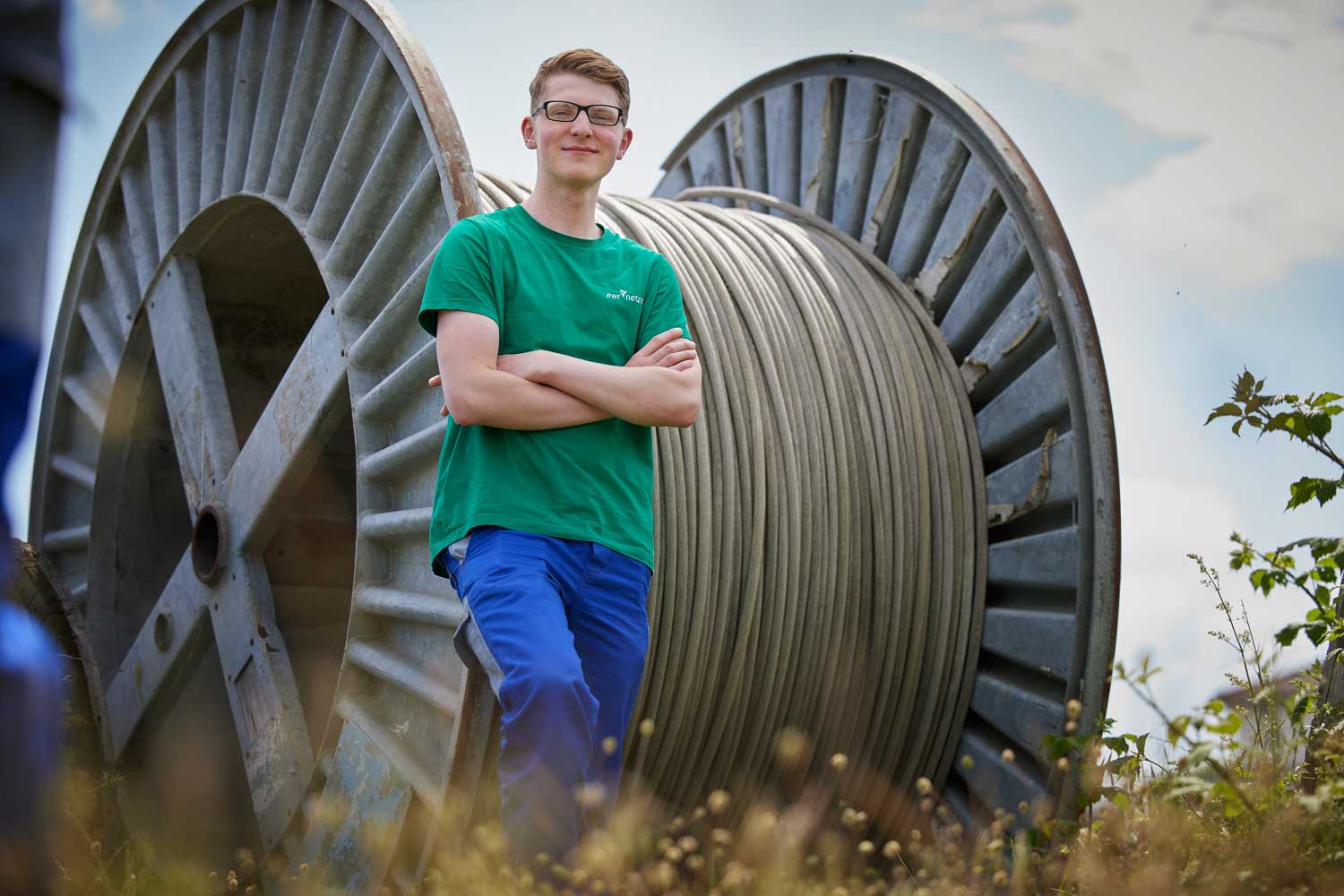 Azubi steht vor Kabeltrommel