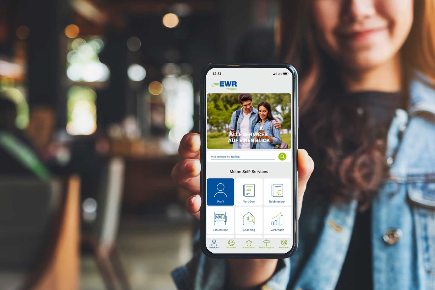 Eine Frau hält ein Handy in der Hand. Auf dem Handy ist die EWR Connect App zu sehen.