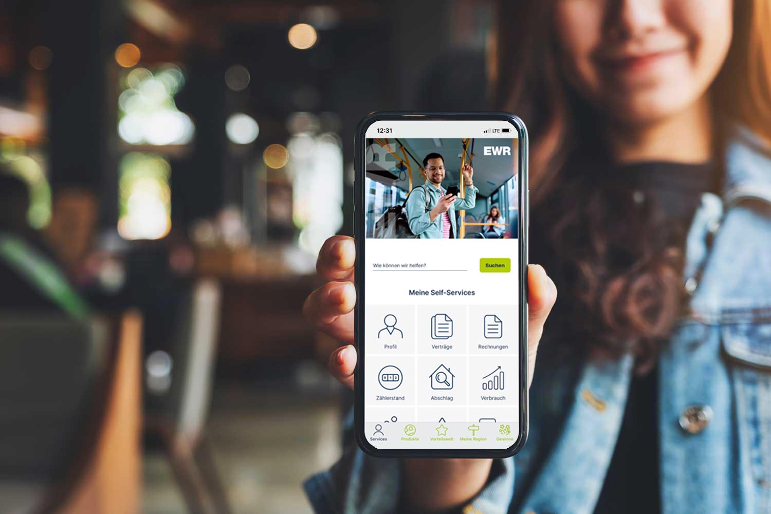 Person hält ein Smartphone in der Hand, auf dem die EWR Connect App mit einer Übersicht zu Self Services wie Profil, Verträge, Rechnungen und Zählerstand angezeigt wird.