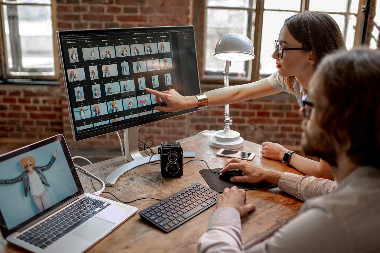 Mitarbeiter sitzen am Computer und schauen auf eine Bildatenbank