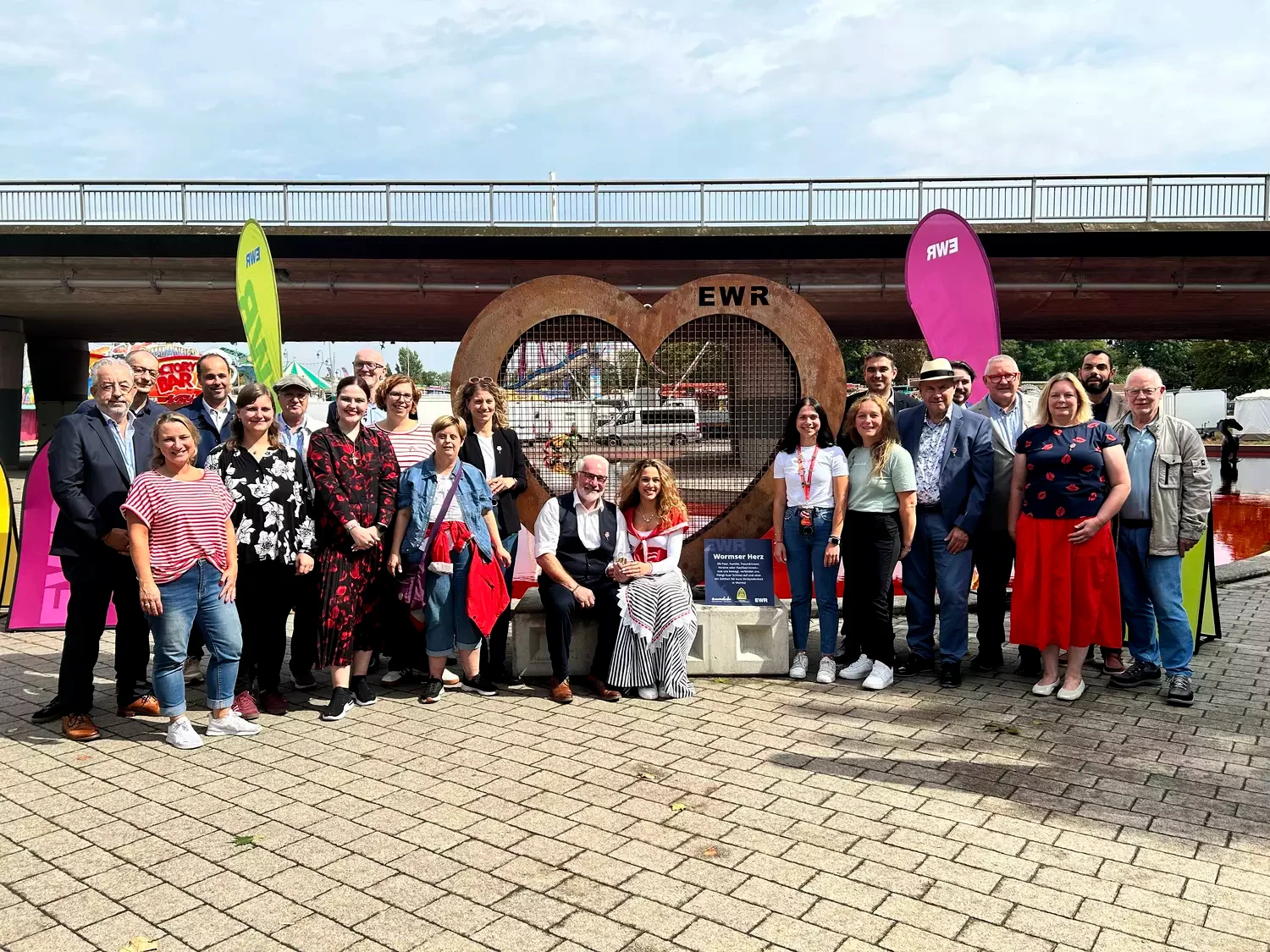 Personen stehen vor einem großen Metallherz vor dem Wormser Marktplatz