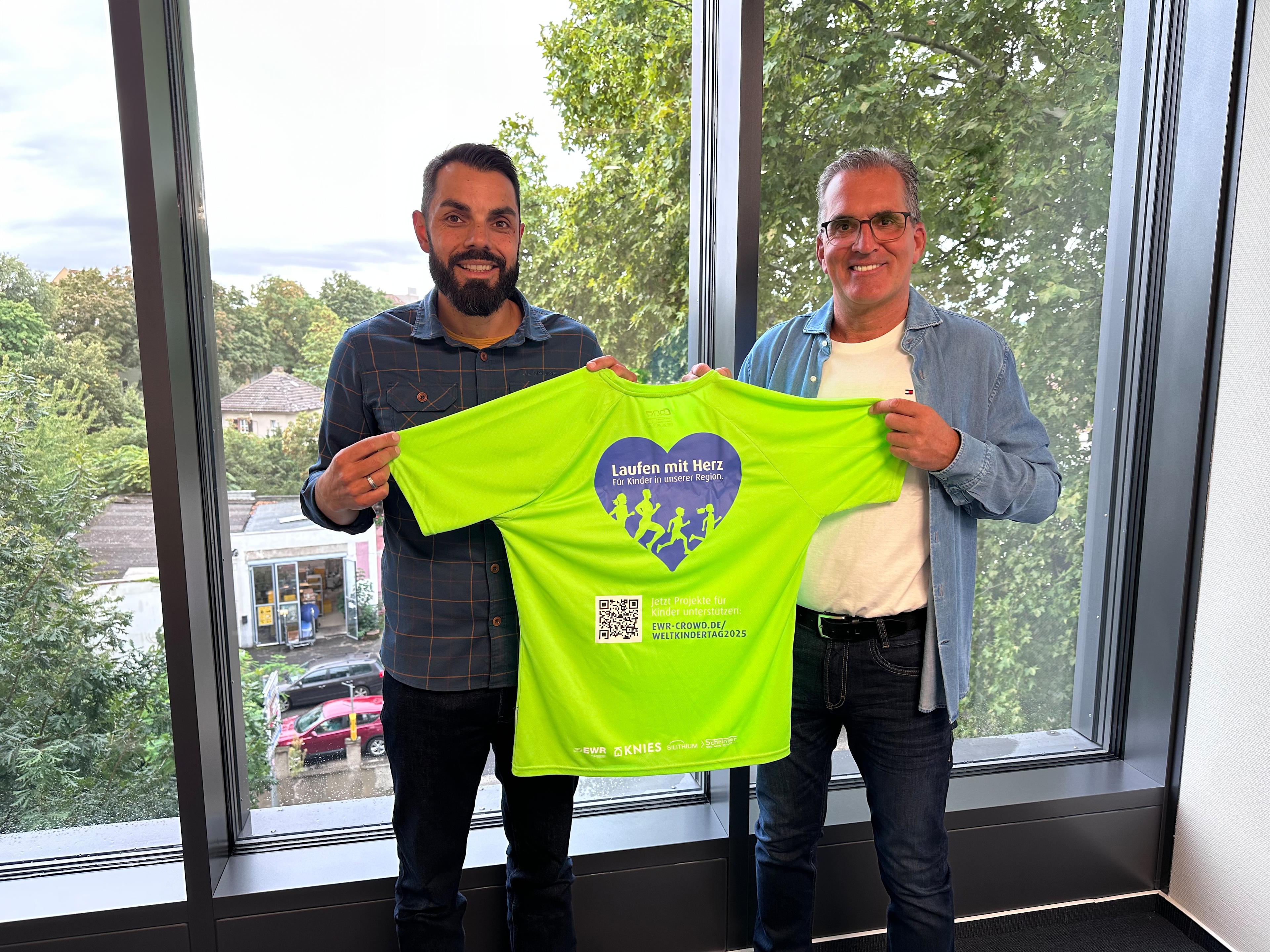 Dominik Nagel und Jürgen Fuchs präsentieren das EWR-Laufshirt für den Nibelungenlauf.