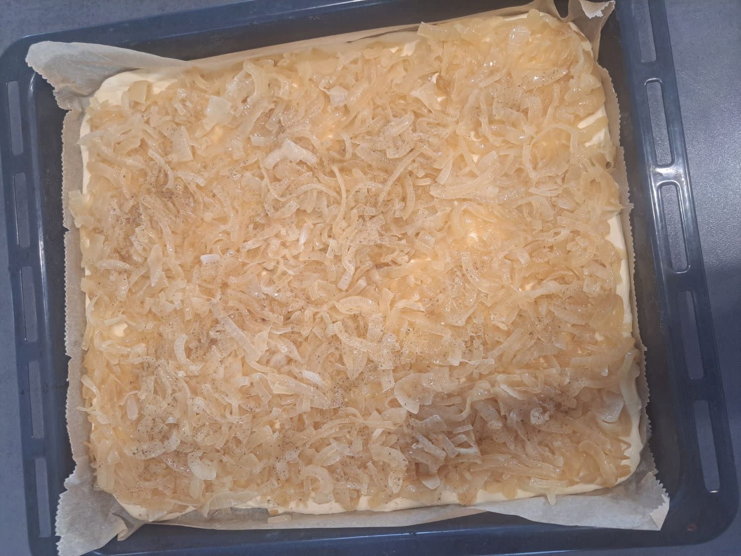 Die angedünsteten Zwiebel auf Hefeteig verteilt