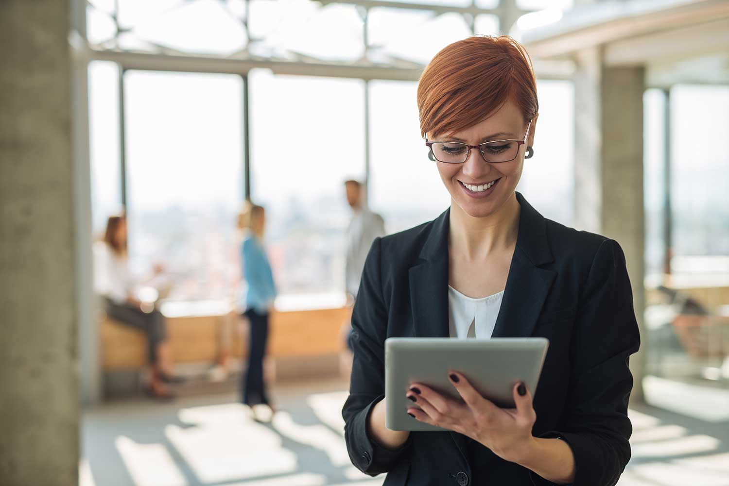 Frau liest lachend etwas auf dem Tablet