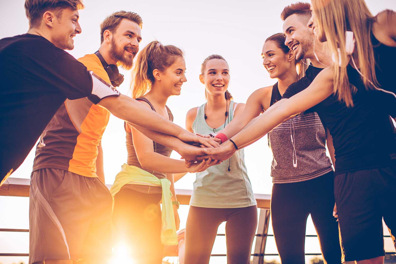 Eine Gruppe sportlicher Menschen die teamcheck mit den Händen machen
