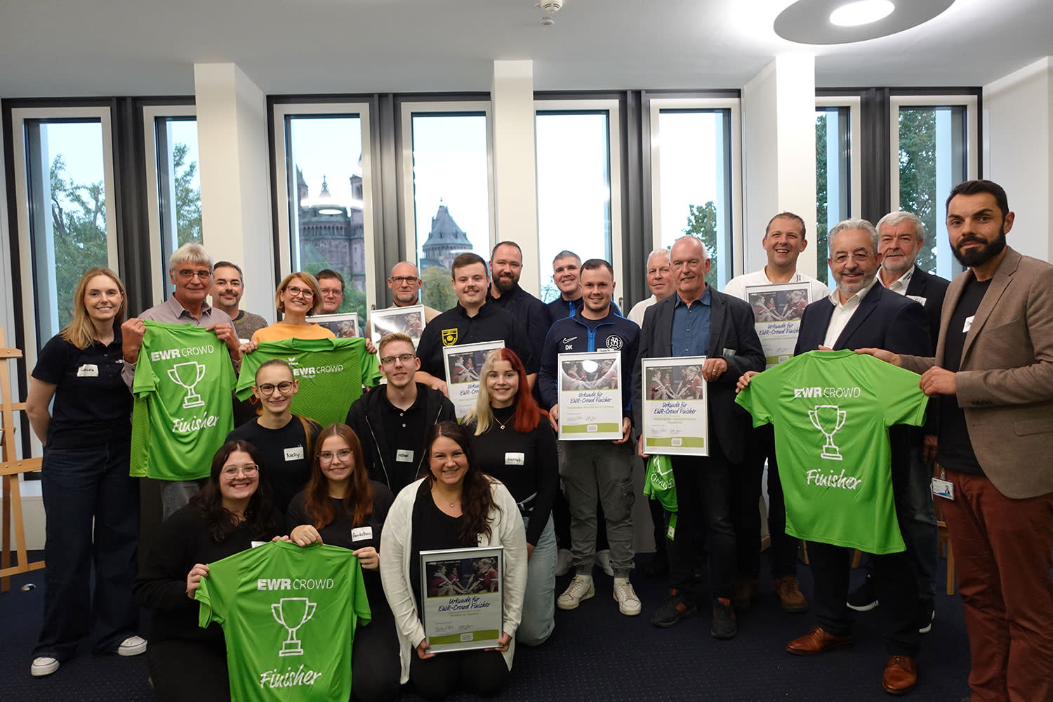 Foto von Urkundenübergabe beim Get-Together mit Vereinsvertrerinnen und -vertretern sowie EWR-Mitarbeitenden.