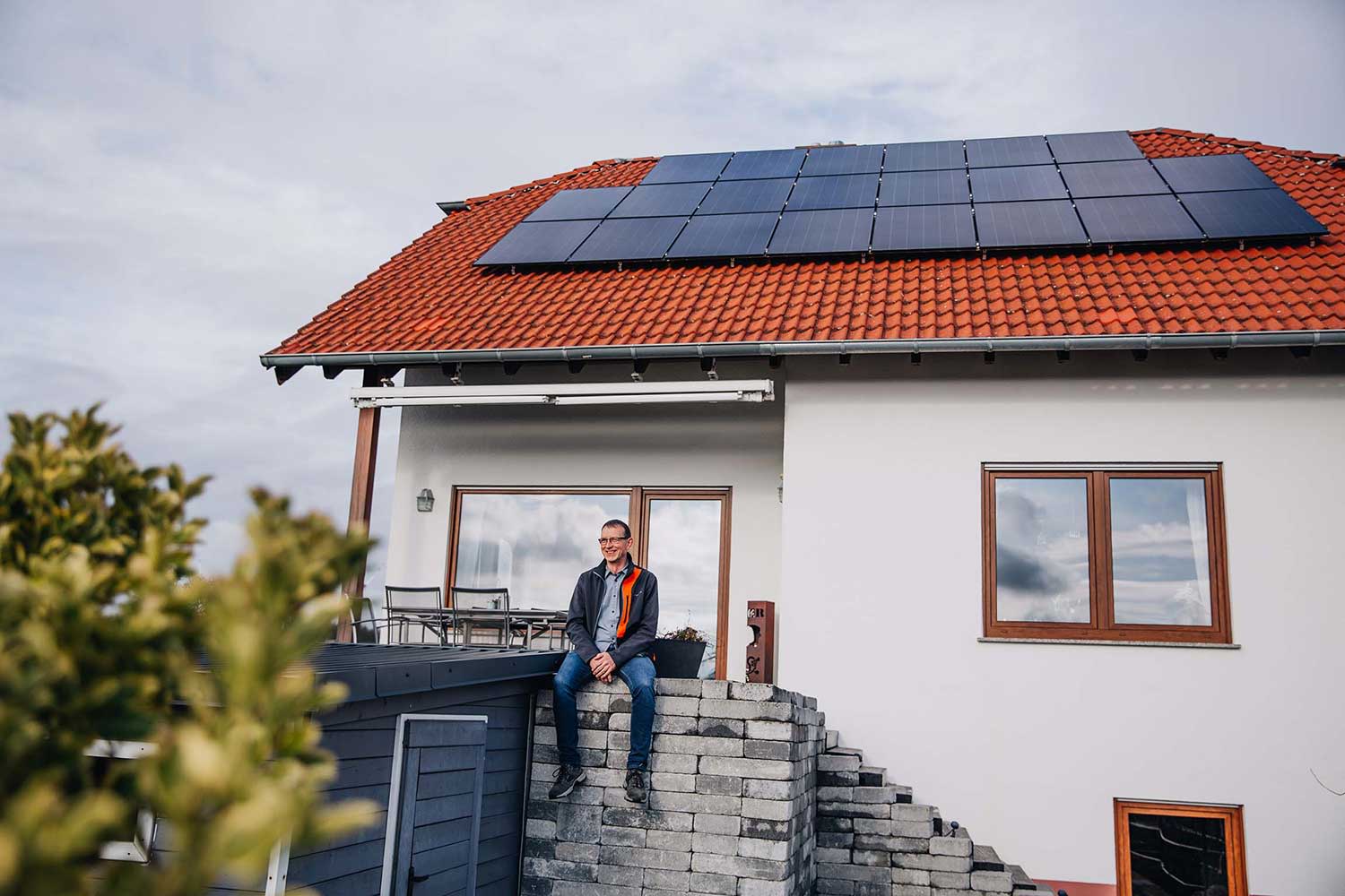 Titelbild Jochen Sauerborn vor seinem Haus in Eppelsheim mit PV auf dem Dach.