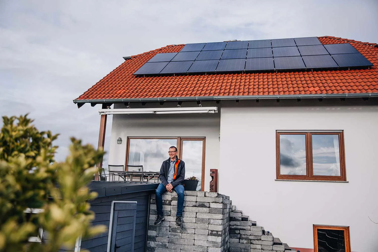 Titelbild Jochen Sauerborn vor seinem Haus in Eppelsheim mit PV auf dem Dach.