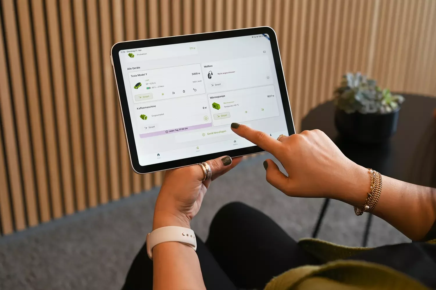 Frauenhand hält Tablet mit dem EWR One Manager auf dem Bildschirm.