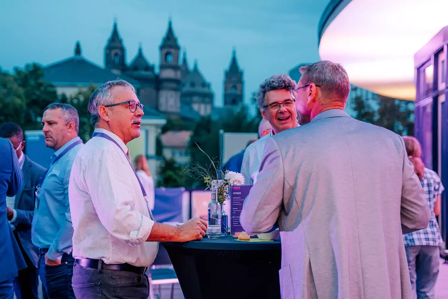 Männer stehen fröhlich auf der Dachterrasse beim Zukunftsforum 26 zusammen
