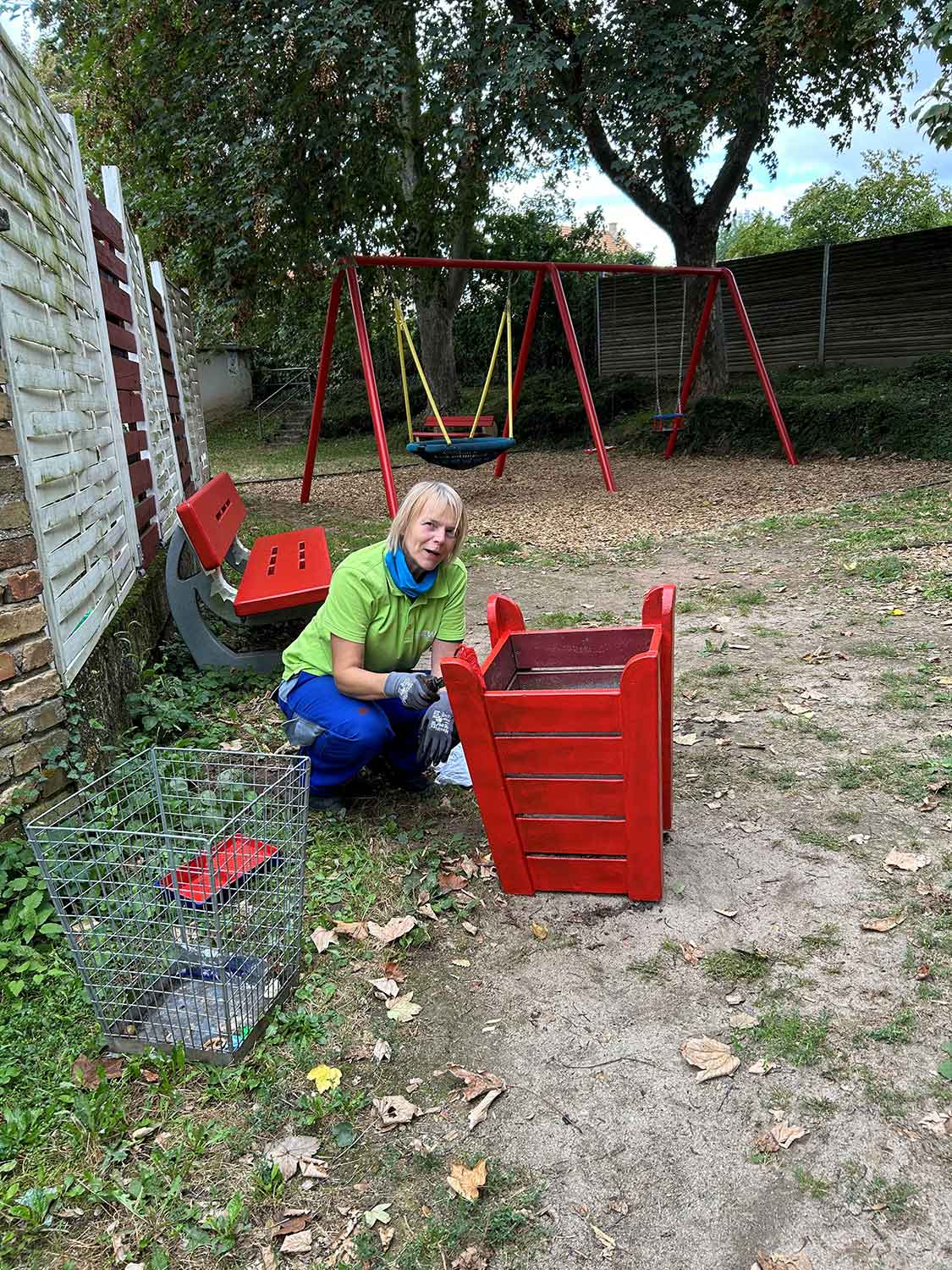EWR Helferin beim streichen eines Spielgerätes.