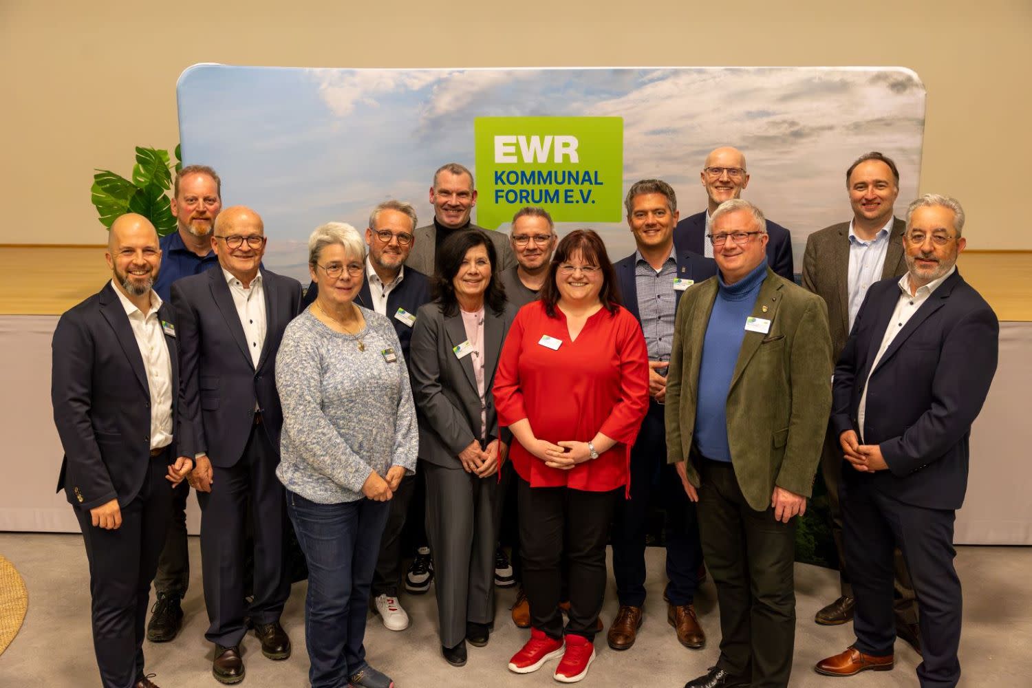 Eine Personengruppe lässt sich vor einer Fotoleinwand des EWR-Kommunalforums e.V. fotografieren