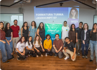 A group of young talents smiles at the camera, surrounded by a green banner featuring the Generation and SumUp logos. In the background, a screen displays “Formatura Turma JavaScript 07.”