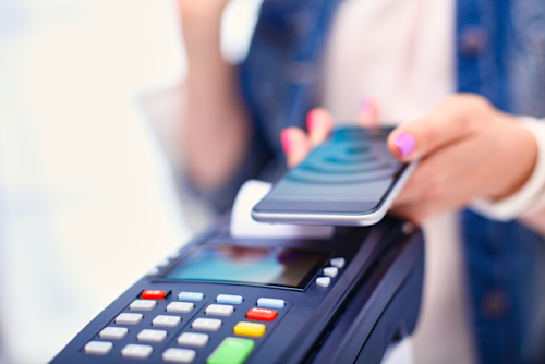 Person making a payment with their phone at a POS.