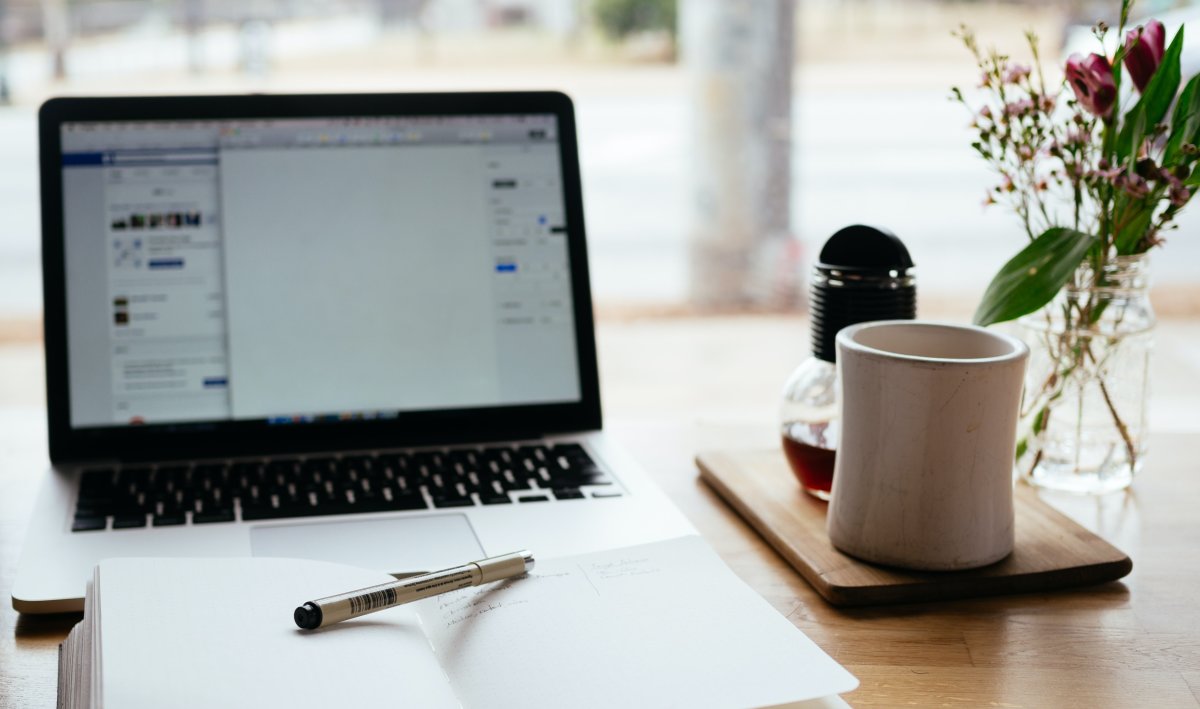 Planung am Computer mit einem Notizbuch und Tasse auf dem Tisch - No Shows