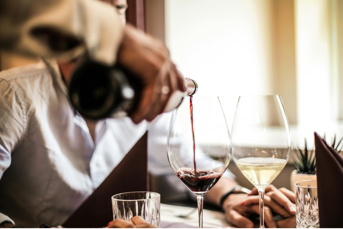 Kellner schenkt Wein im Restaurant ein