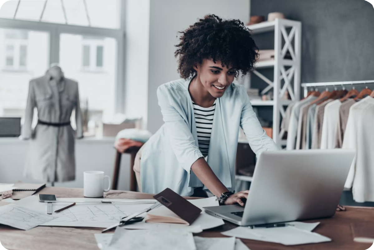 Smiling black woman business owner working on computer.