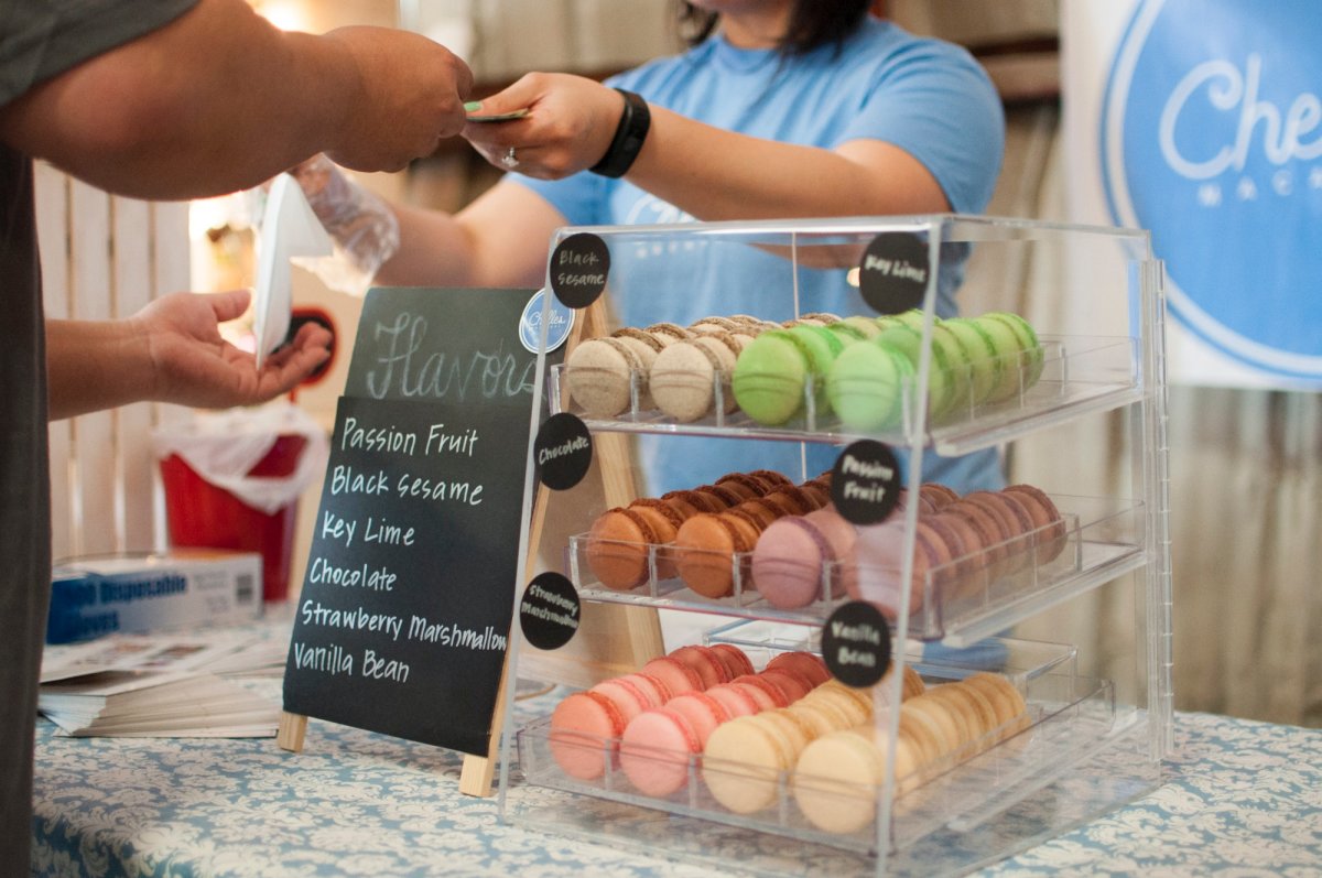 person buying macroons in front of an assorted macroon display