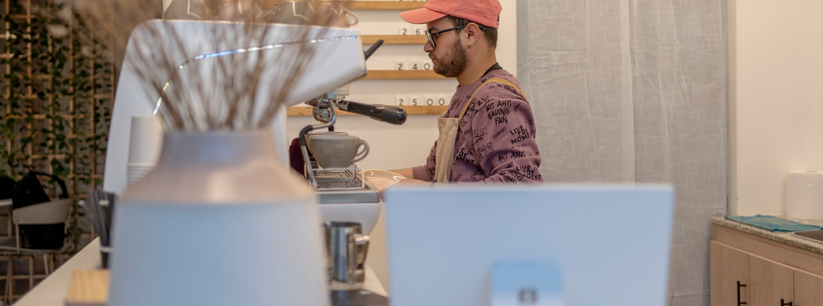 Mann bedient im Café mit Zahlungsterminal von SumUp