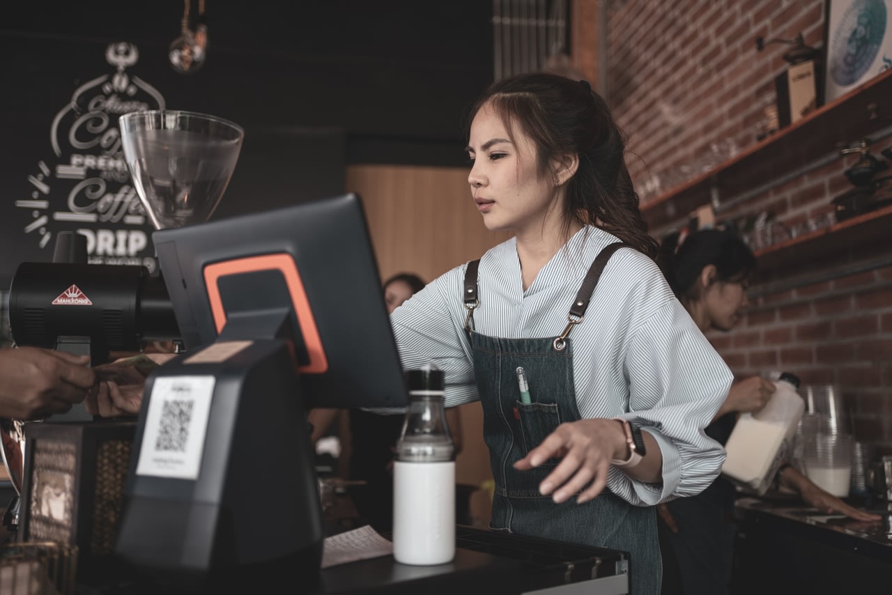 Cashier at cafe using POS system