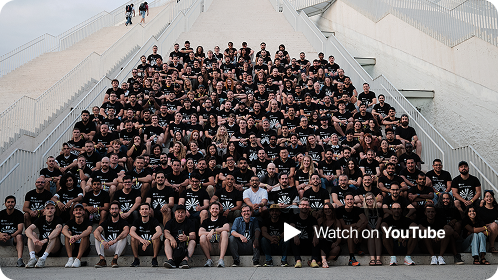 A large group of SumUp team members wearing black Hack Week 2024 t-shirts are seated on the steps of the Pyramid of Tirana, posing for a group photo, with a 'Watch on YouTube' button overlay in the corner.