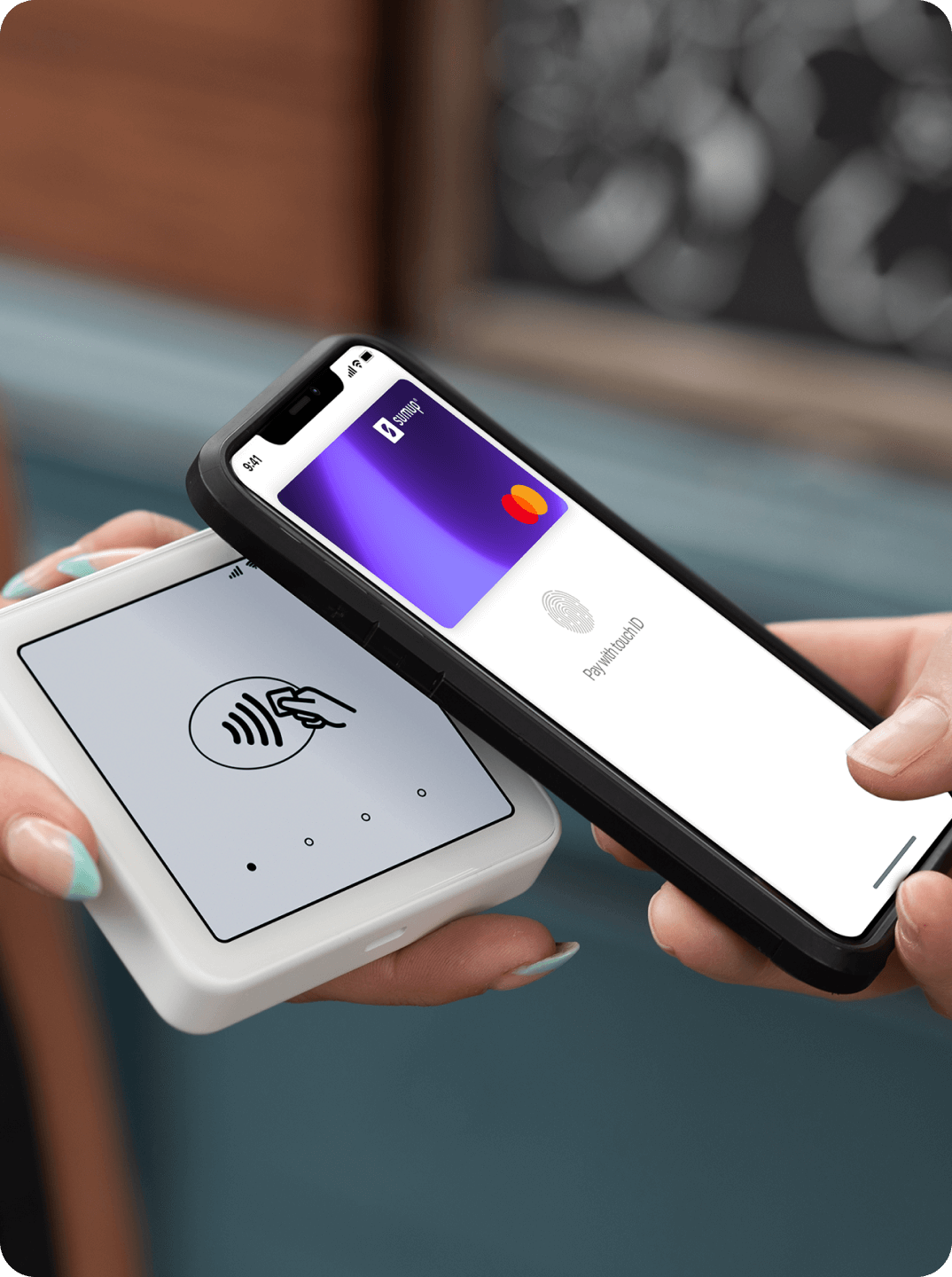 Person making a contactless payment with SumUp Pay on a smartphone, held near a SumUp card reader.