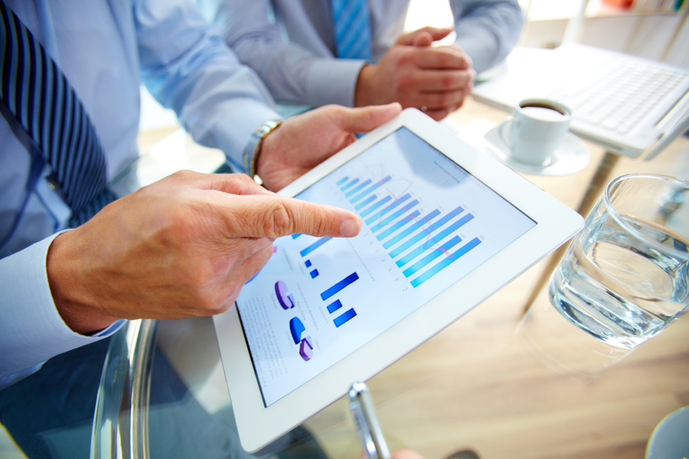 Businessman looking at graphs on a tablet.