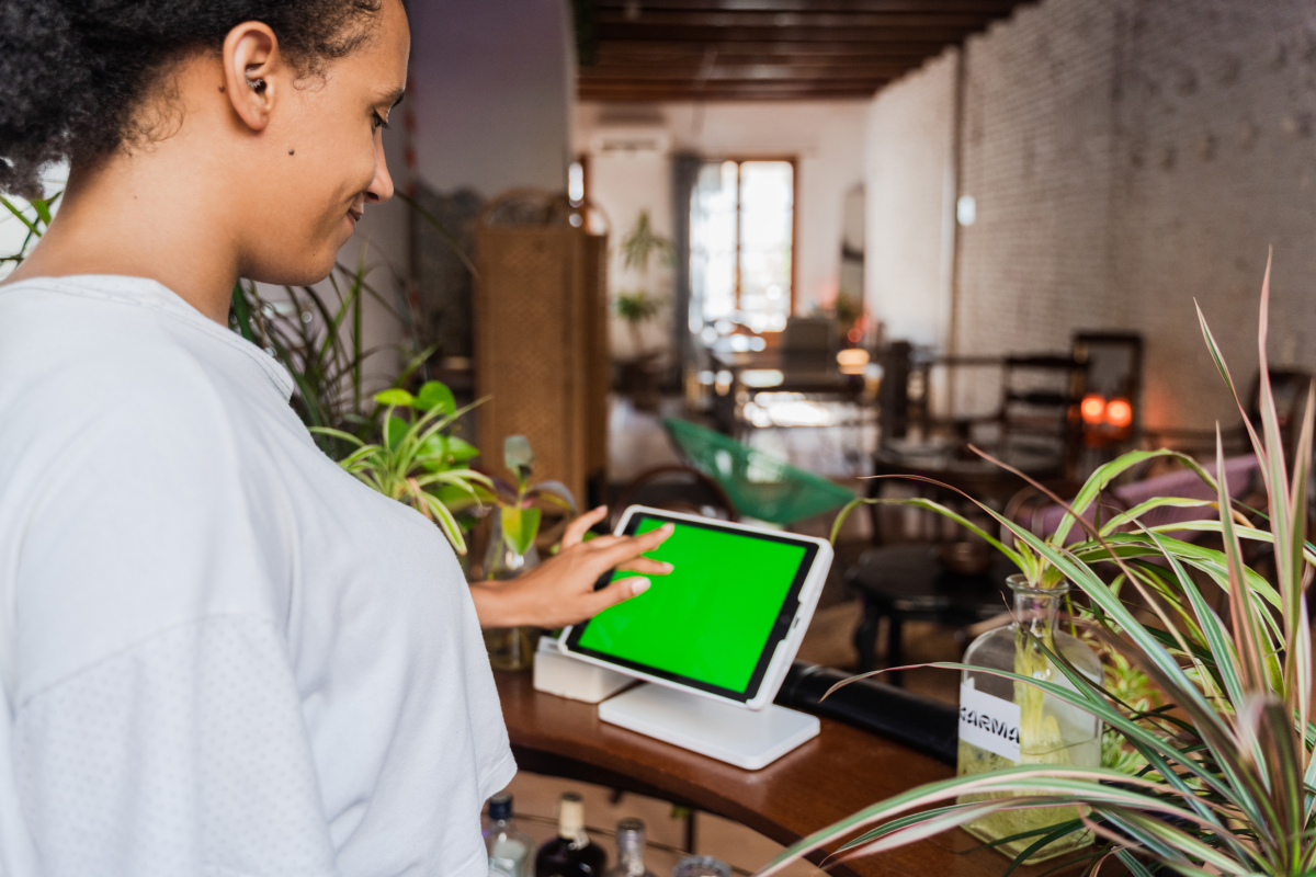 Frau nutzt Kartenterminal in ihrem Restaurant