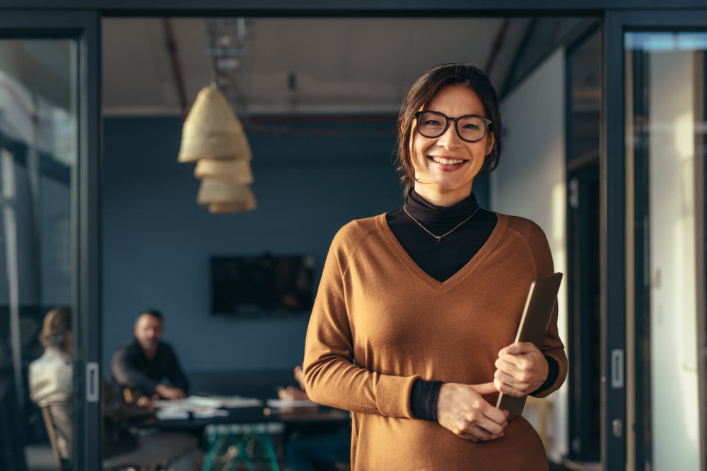 happy female business owner  holding a laptop