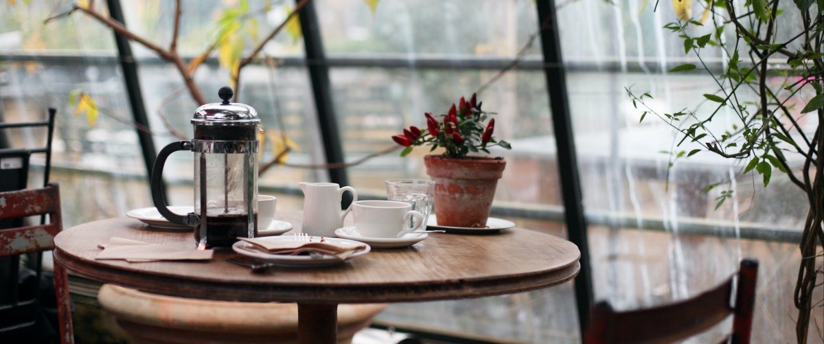 Kaffeekanne auf einem Café-Tisch im Außenbereich mit Café Ausstattung
