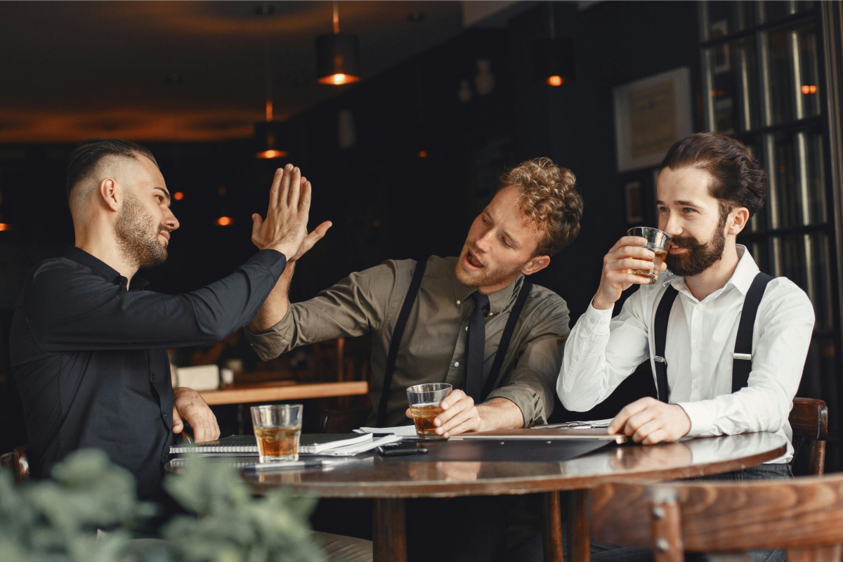 Drei Männer sitzen in Bar