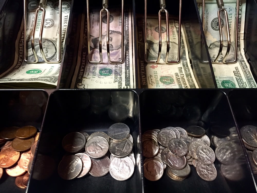 American dollar notes and coins inside the cash register machine