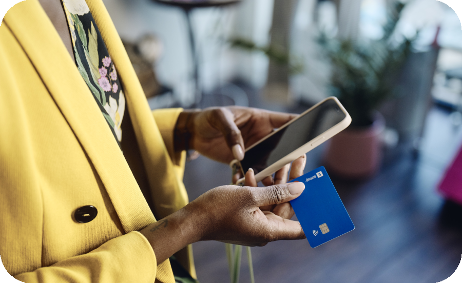 Image of a person holding a phone and a credit card