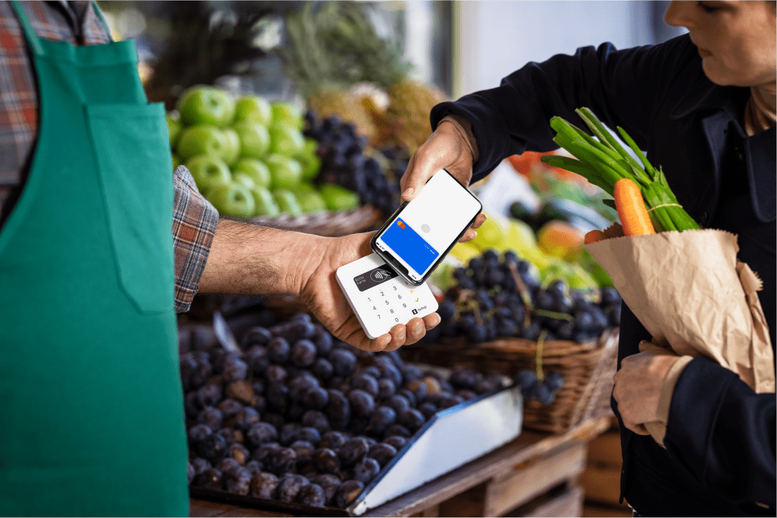 Kunde zahlt beim Gemüsehändler mit dem Handy