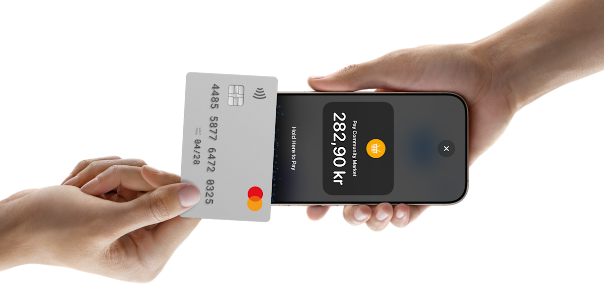 Someone tapping a card on a phone to pay for something