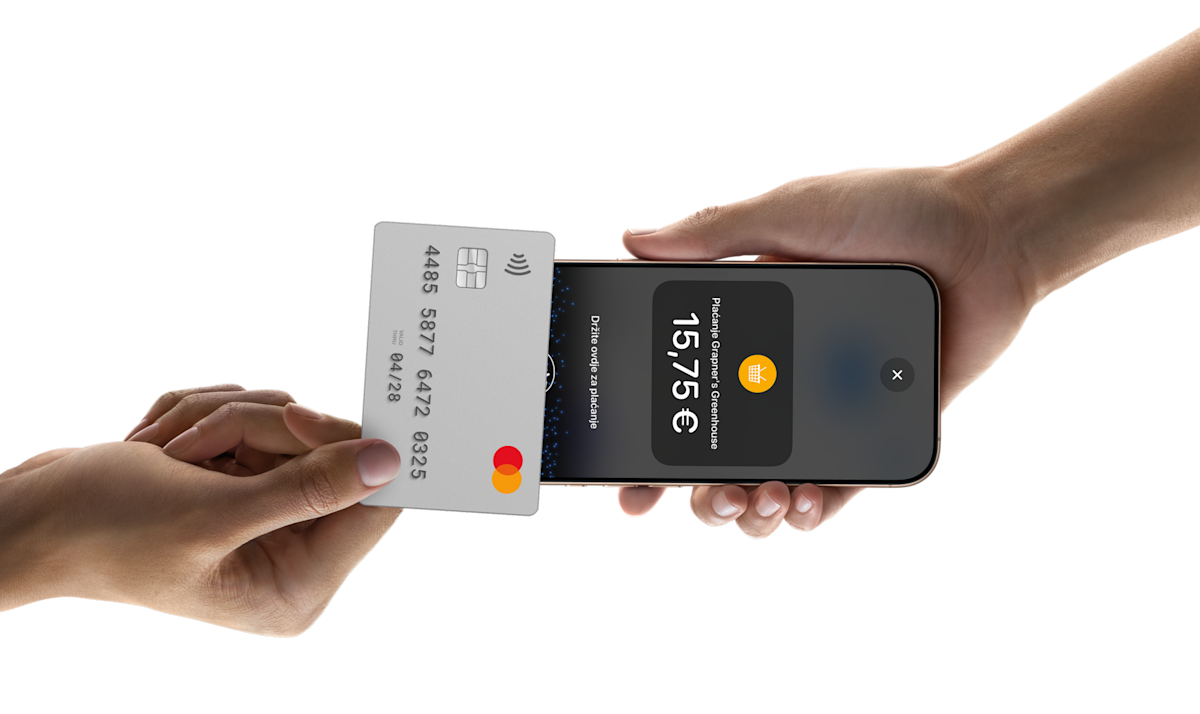 Someone tapping a card on a phone to pay for something