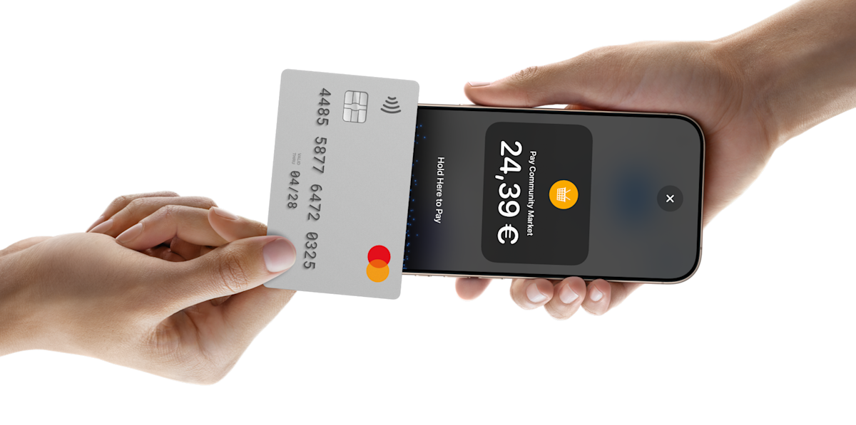 Someone tapping a card on a phone to pay for something