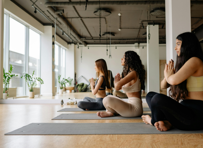 Frauen beim Yoga Kurs in einem Fitness Studio