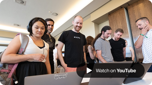 A group of SumUp team members gathered around a laptop, smiling and engaged during a Hack Week 2022 project showcase, with a 'Watch on YouTube' button overlay in the corner.
