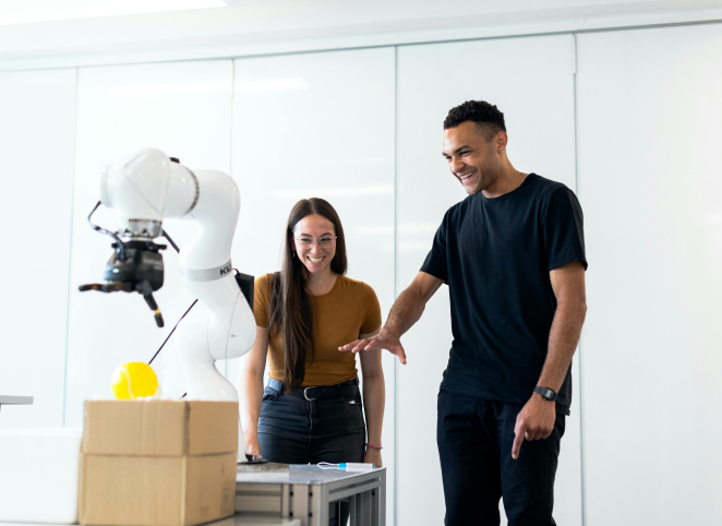 Mann und Frau mit Roboter in Fabrik