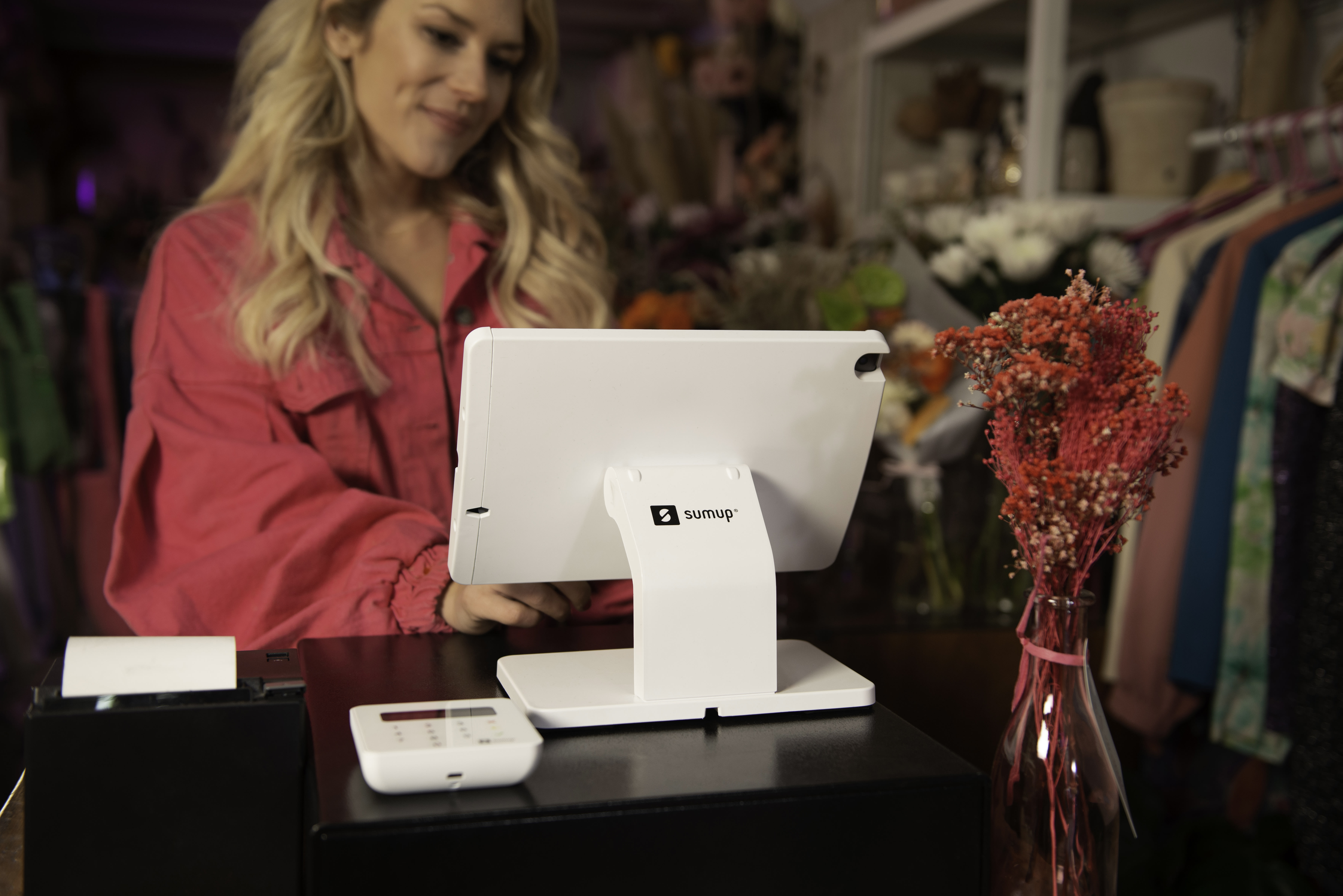 SumUp retail point of sale system on the sales counter at a retail store with employee.