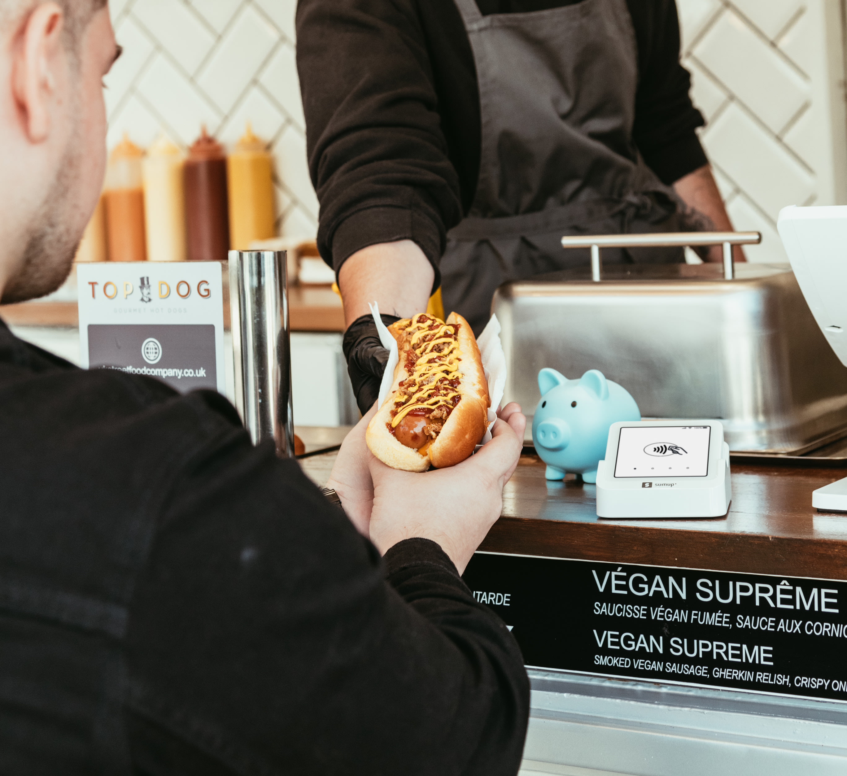 Food truck owner handing customer food.