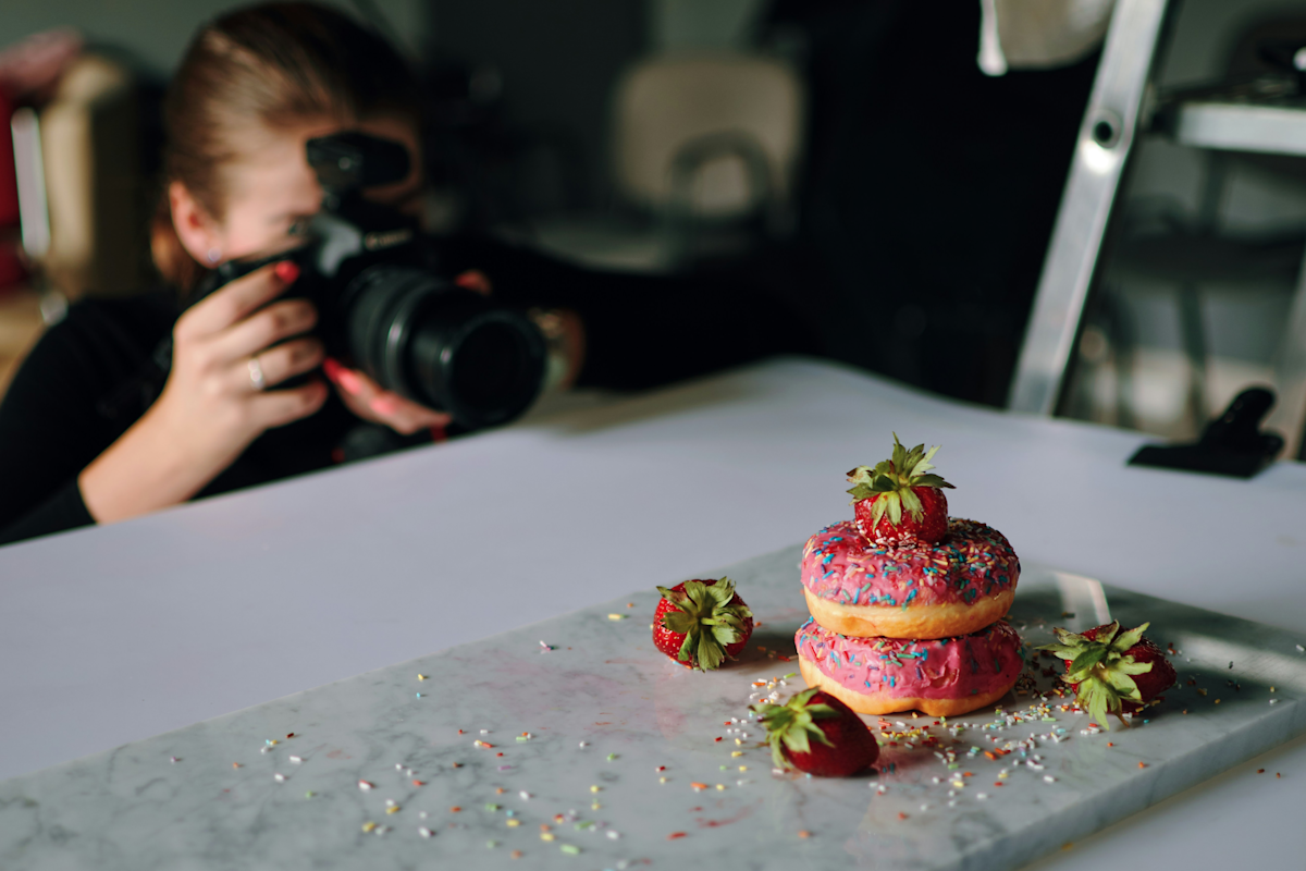 Frau macht Produktfotos von Essen ihres Cafés