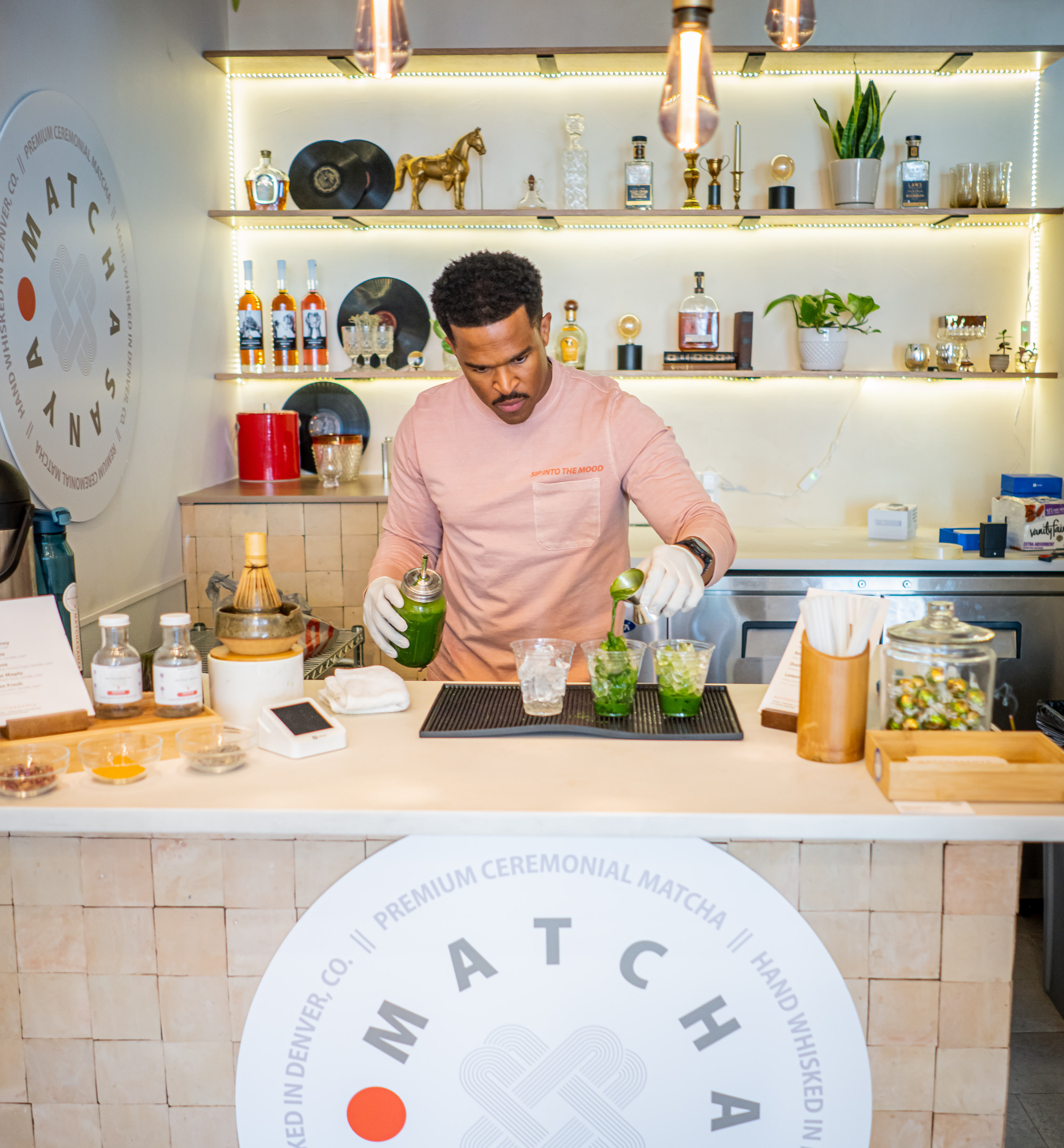 Coffee shop owner pouring matcha into cups on the bar of the restaurant.